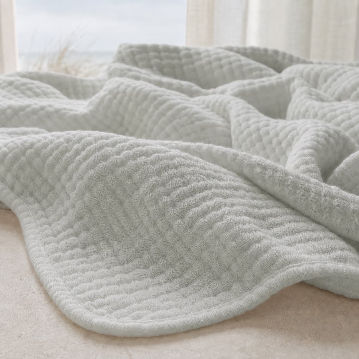 Close-up of the pale grey texture of a lightweight muslin blanket